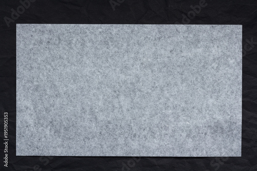 sheet of thin translucent tissue paper on a black background