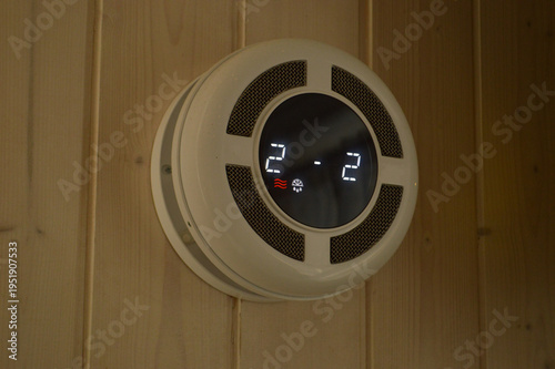 Smart ventilation unit with digital display mounted on a wooden wall