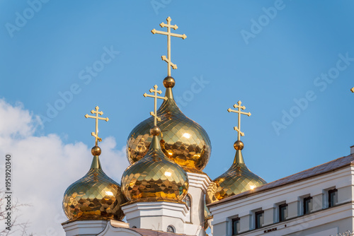 Gilded dome with a cross of an Orthodox church against a blue clear sky