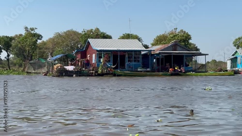 View from boat passing floating houses in Prek Toal village on Tonle Sap Lake Cambodia. Continuous scene of daily life on water in Southeast Asia.