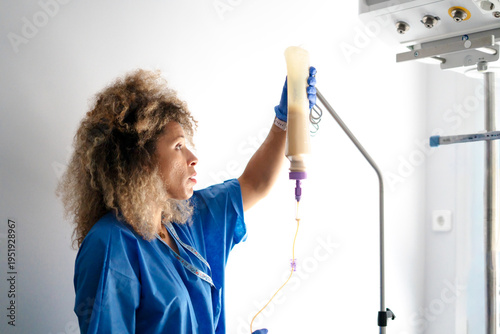 Bild auf Leinwand Healthcare professional adjusting enteral feeding in hospital room