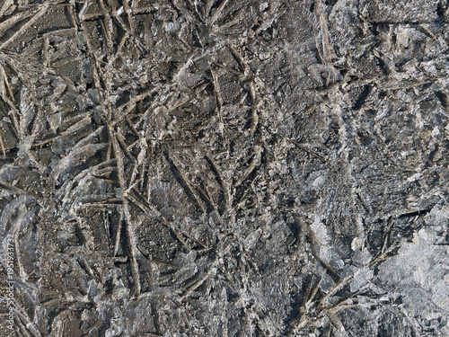Close‑up of cracked and textured ice with intricate frozen patterns, fractured shards, and rough crystalline surfaces creating a natural winter abstract background.