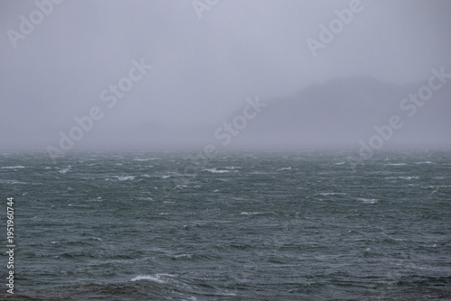 Ocean waves under heavy mist and grey sky