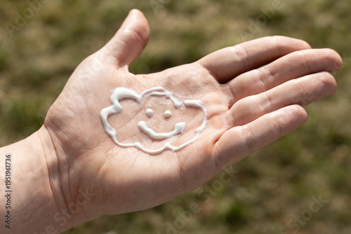Closeup of a man using the correct amount of sunscreen on a cloudy day.