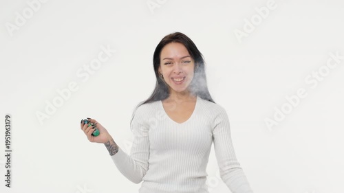 Young adult woman smoking an electronic cigarette white background isolated space