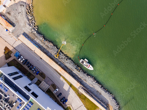 Foto Boat works on water area near shore with machinery at a construction site during