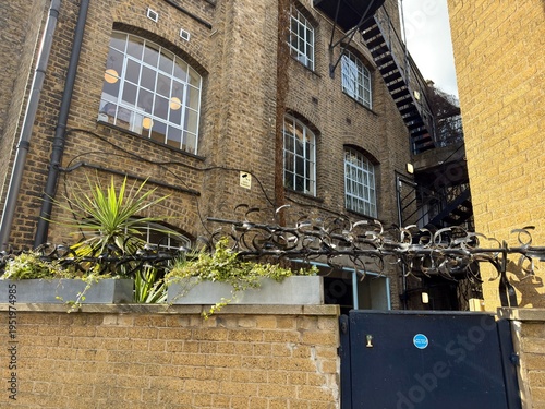 Barbed Wire Security: Intense barbed wire fencing protecting a small private enclave in an urban London setting.