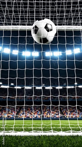 Soccer ball entering the net during a nighttime game