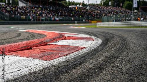 Close up view of a race track's corner with crowd in the background