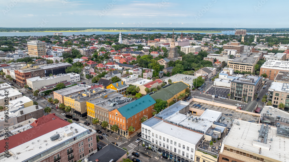 Fototapeta premium Aerial view of downtown Charleston, South Carolina skyline showcasing historic churches, colorful buildings, and neighborhoods during morning daylight in the lowcountry cityscape landscape