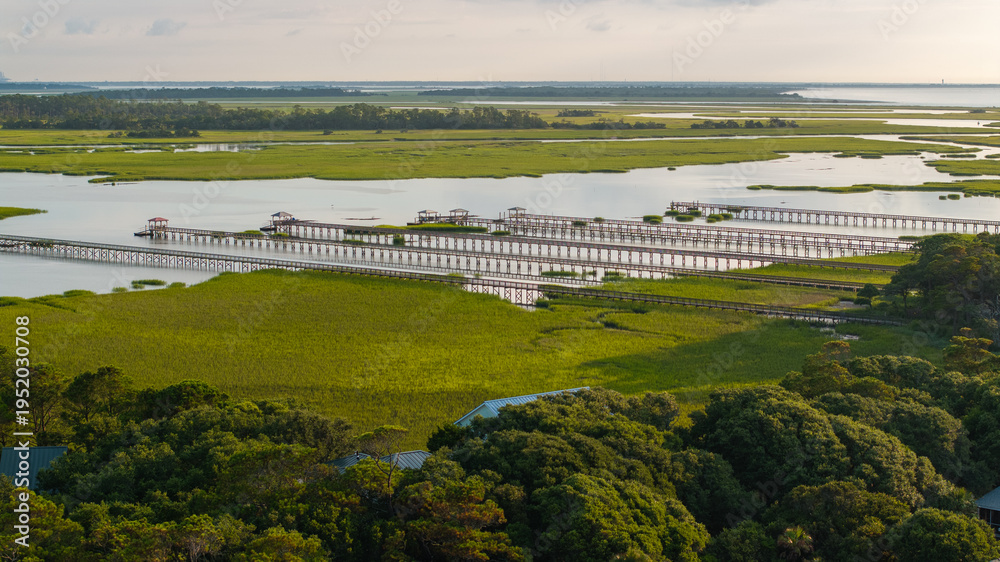 Obraz premium Panoramic Aerial view of marshes and pier boat docks in Folly Beach town near Charleston, South Carolina landscape during morning sunrise