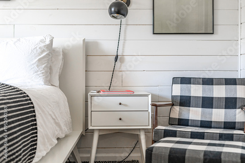 Obraz na plátně Cozy modern bedroom corner with white shiplap wall, bedside table and plaid loun