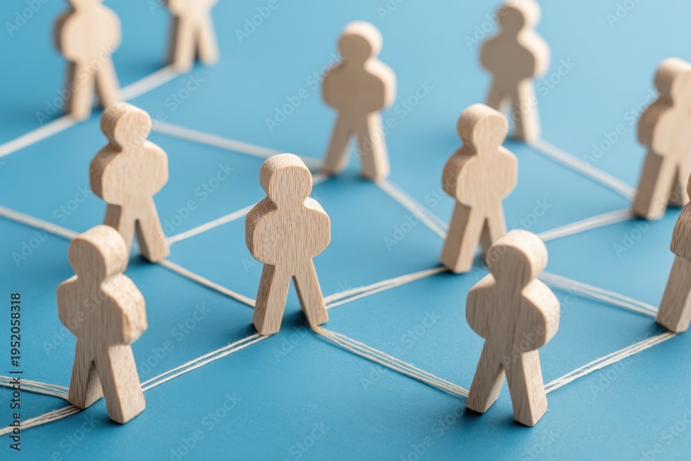 Obraz premium Networked: A conceptual image of interconnectedness, depicting wooden figures linked together by lines, suggesting a network or system.