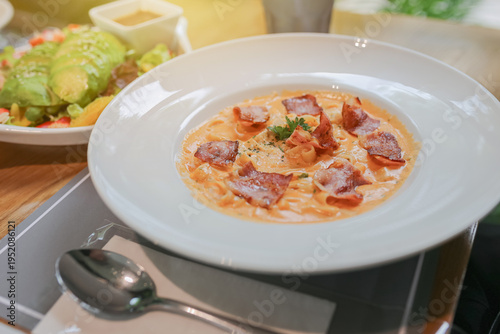 spaghetti carbonara on white dish, Creamy pasta carbonara with bacon bits and fresh parsley garnish served in white bowl. Classic Italian cuisine dish with rich sauce and herbs for dinner.