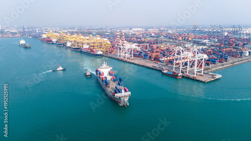Massive container ship navigating near a busy commercial port terminal loaded with colorful freight. Global maritime trade logistics, supply chain, and international cargo export concept.