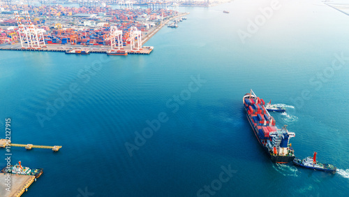 Cuadro en lienzo large container ship assisted by two tugboats in the deep blue sea