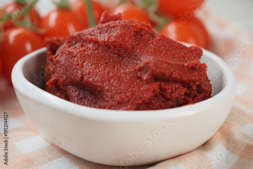 Obraz na plátně Tomato paste in a white bowl with fresh tomatoes nearby