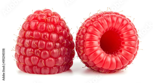 Fresh raspberries, one cut in half, on white background