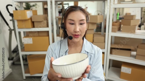 Customer, support, service, communication, ecommerce, telemarketing seller woman examines ceramic bowl while on headset call, discussing product details and quality with buyer from home business work