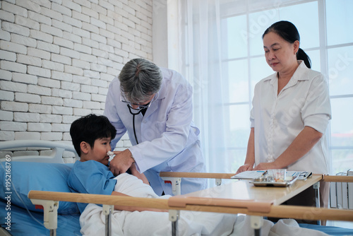 Professional White doctor visits, exams, and checkups sick Asian patient boy in pediatric hospital ward, child illness healthcare consultation and medic physician, diagnosis advice to parent worried.