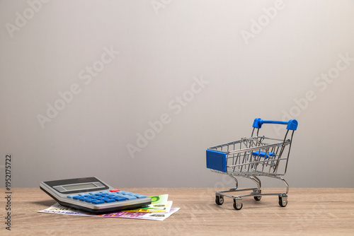 Calculating shopping budget with calculator and miniature cart
