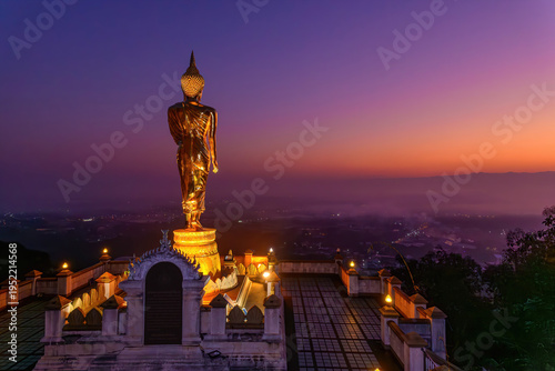 Standing Golden Buddha statue at Phra That Khao Noi Temple, Nan Province, Thailand.