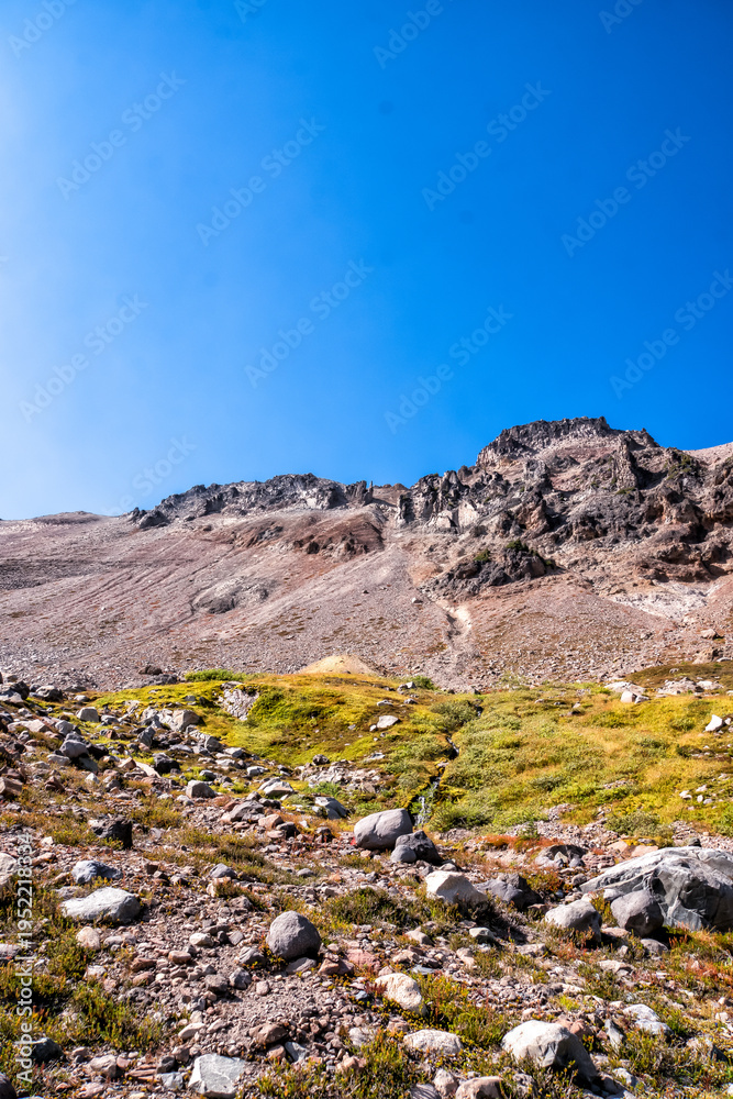 Fototapeta premium Rugged mountains rise beneath a clear, vivid blue sky
