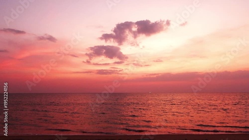 Red pink sunset purple sky over calm ocean wave n sea water with colorful dark rain stom cloud n cumulus cloudscape in twilight sunlight n sun ray at Tropical summer sandy beach, 4k Phuket thailand