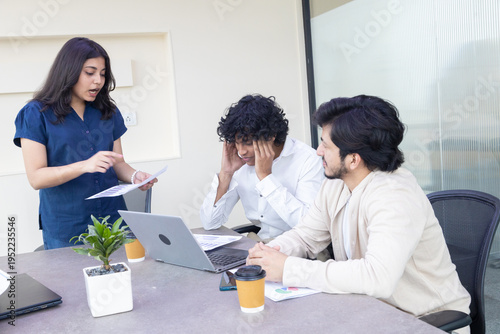 Indian female boss entrepreneur expressing dissatisfaction with employees or colleague and pointing mistake in project report or Businesswoman unhappy with performance of team. Loss of company