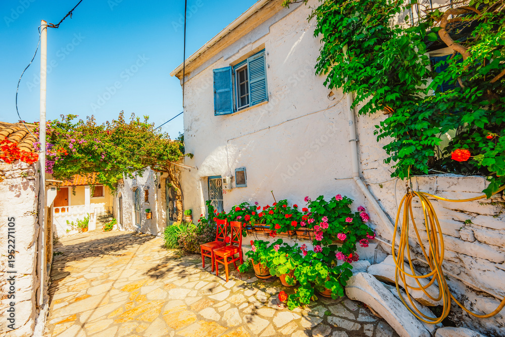 Fototapeta premium Alley decorated with flowers in the picturesque village of Afionas vacation on the island of Corfu in Greece near Porto Timoni beach
