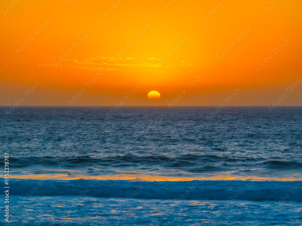 Fototapeta premium Sunrise at the Seaside with a hazy cloudless sky