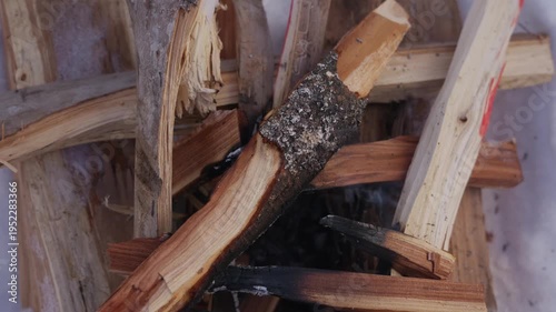 Wallpaper Mural Close-up of firewood slowly burning and smoking in a small winter campfire. Thin smoke rises between wooden logs inside a snow pit during cold outdoor conditions. High quality 4k footage Torontodigital.ca
