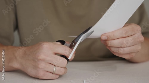 Wallpaper Mural Hands using scissors to cut a piece of white paper on a table surface. Detailed view of simple craft or office task. High quality 4k footage Torontodigital.ca