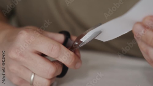 Wallpaper Mural Close view of hands carefully cutting a white paper sheet with scissors. The blades move steadily through the material during a simple crafting or office activity. High quality 4k footage Torontodigital.ca