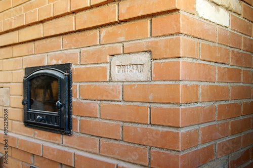 Wood stove made of bricks Red brick fireplace. Decorative insert made of antique fireclay.