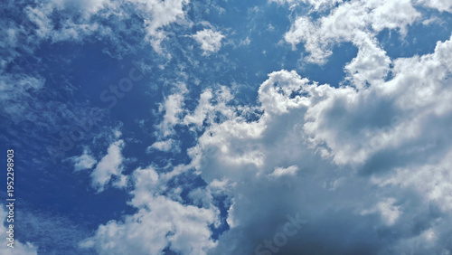 A vivid blue sky filled with scattered white clouds, creating a calm and airy atmosphere with soft natural light.