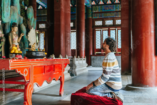 Man kneeling in Beijing temple praying for spirituality