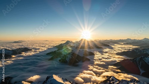 Sunrise over mountain peaks illuminating clouds below, showcasing vibrant colors and dramatic light rays in a breathtaking alpine landscape at dawn