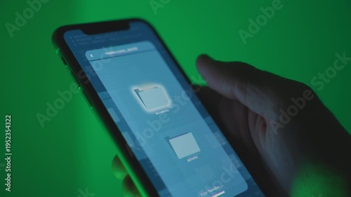 Downloading files to phone with remote access or hacking into system stealing files and data from another device. Control over computer. Hand holding smartphone while copying private sensitive data