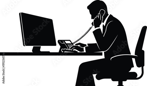 Silhouette of a professional businessman in a suit working at a desk with a computer monitor while talking on a corded office telephone