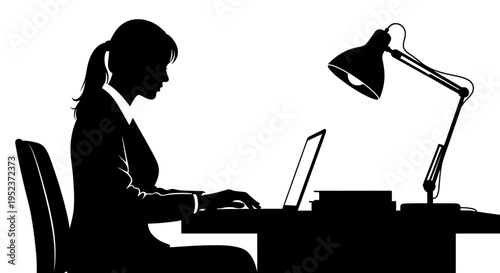 Silhouette of a businesswoman working on a laptop at a desk with a lamp