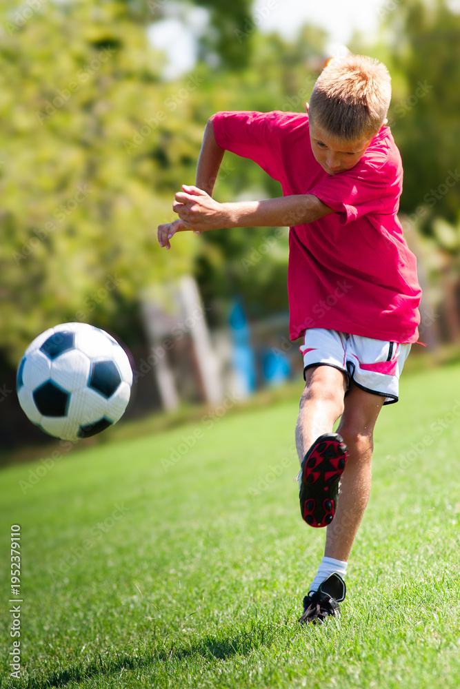 Obraz premium Young boy shooting soccer ball