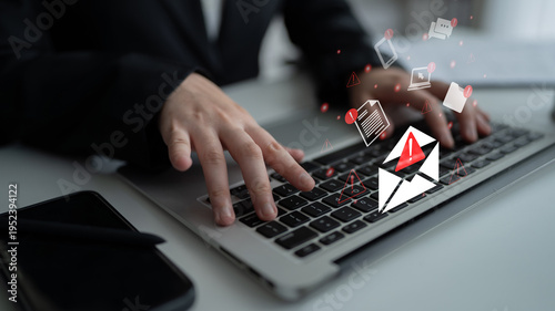 Foto A person types on a laptop keyboard with warning icons appearing above, illustrating the significance of email alerts and cybersecurity awareness in the digital age