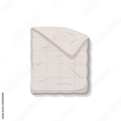 A simple, flat, quilted blanket is folded and casting a subtle shadow