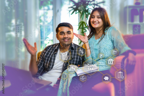 Young Indian couple on sofa discussing an income tax concept while using laptop for financial goals