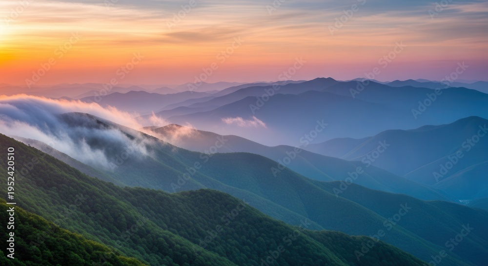Obraz premium Sunset over rolling green mountains with misty clouds at dawn