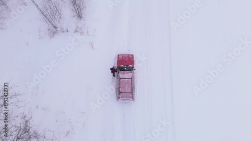 Wallpaper Mural Man exits broken down red car next to snowy winter road in countryside, overhead Torontodigital.ca