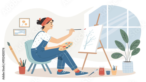 Relaxed female artist painting on canvas in a cozy studio with natural light