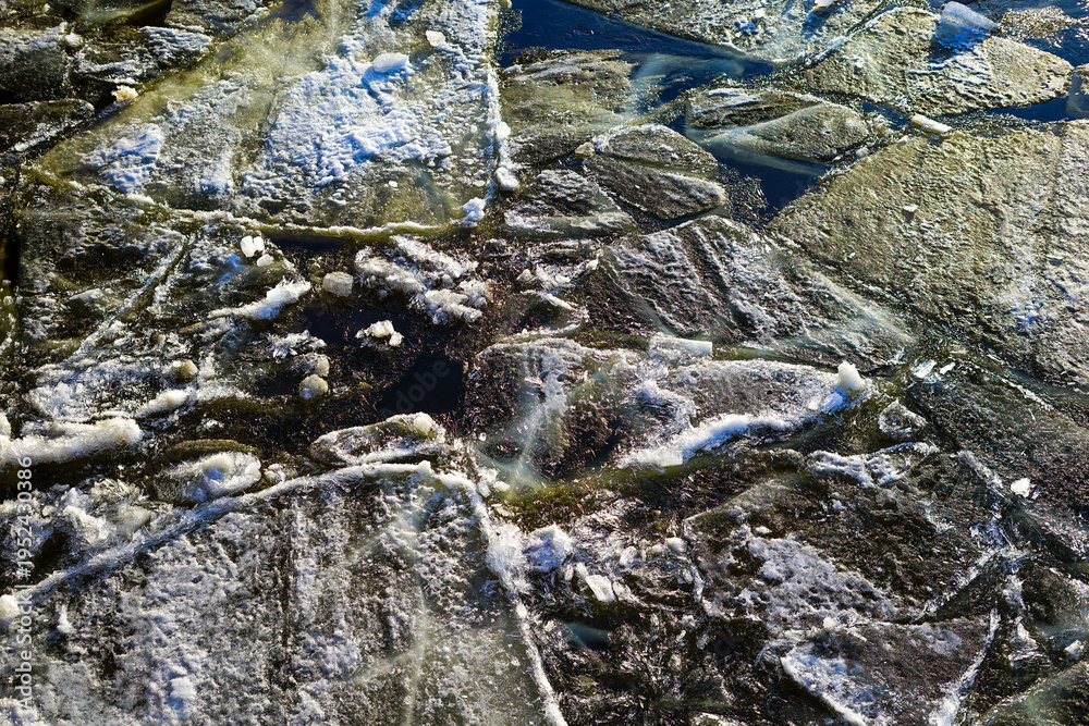 Fototapeta premium Broken Ice Floes on Dark Water in Winter