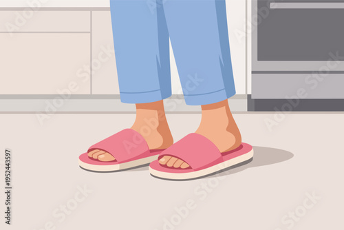 Person feet wearing cozy pink slippers and blue pajamas standing on kitchen floor in morning light
